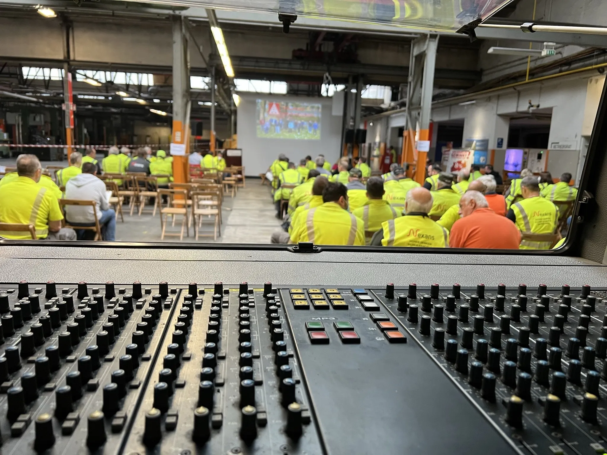 Belegschaft bei einer Betriebsversammlung in der Werkshalle