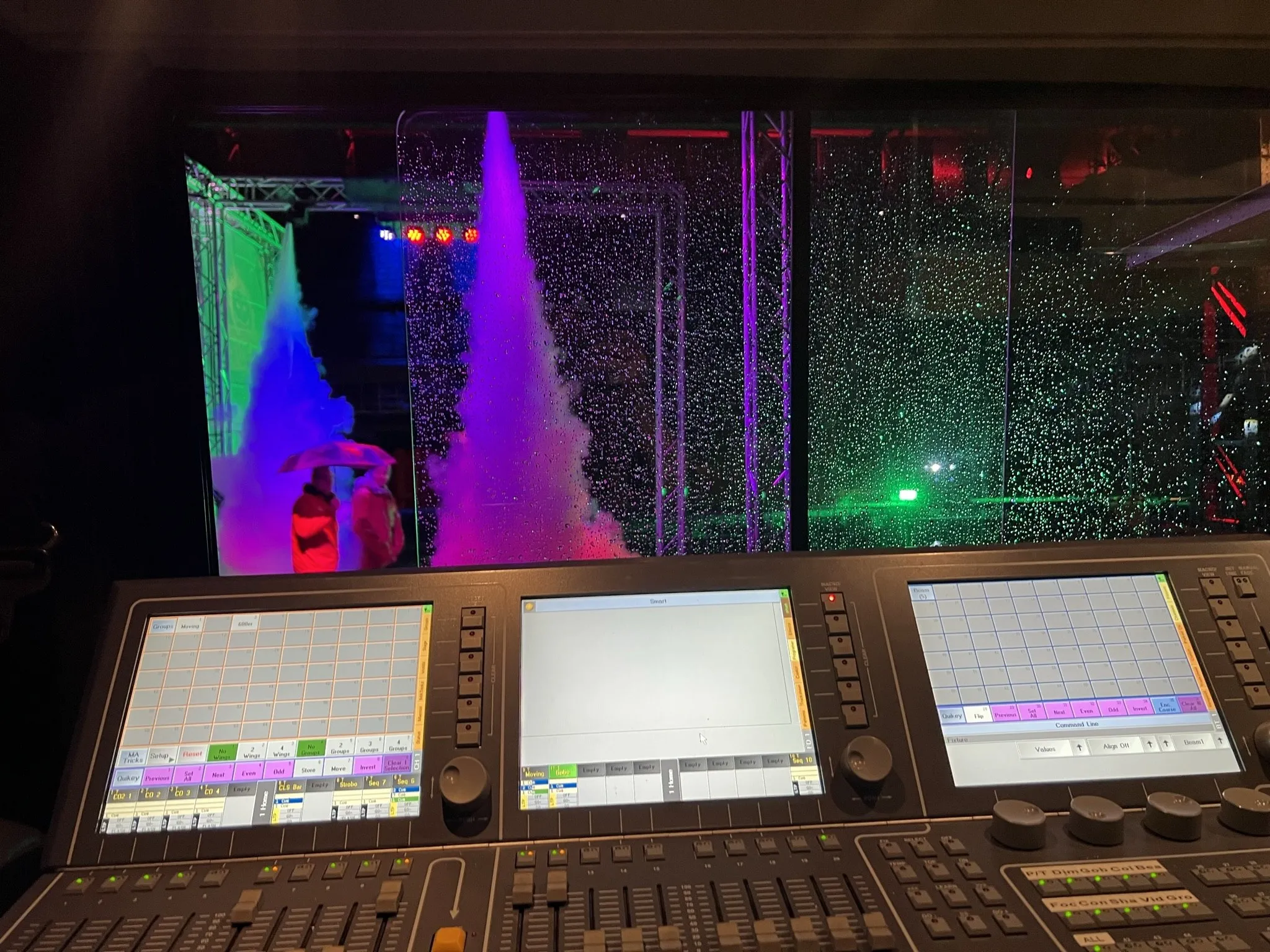 Blick aus dem Lichtpult (grandMA) auf die Halloween-Show: Nebel, Laser und CO2 in Lila und Grün, Läufer im Regen