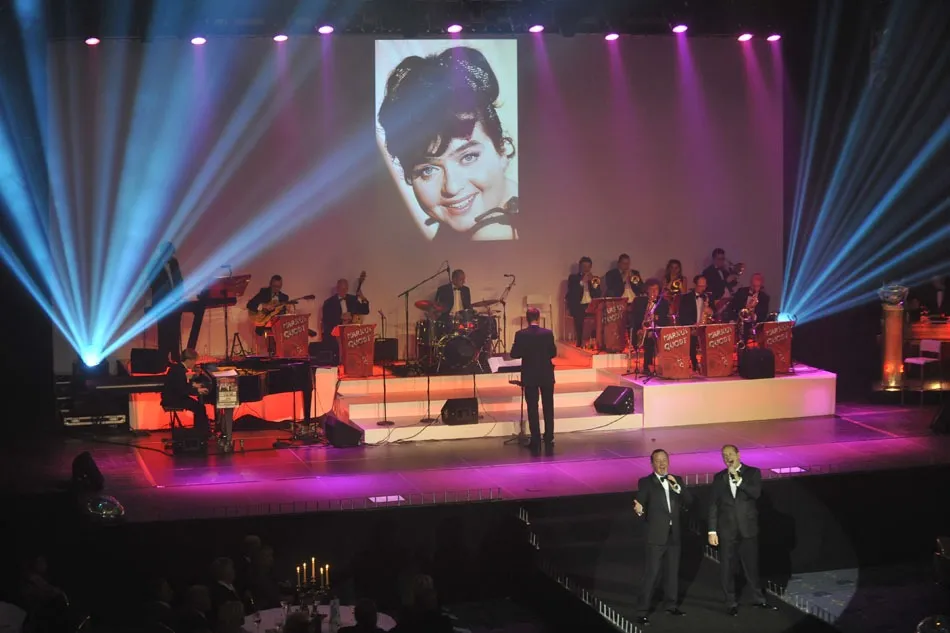 Gala-Abend mit Big Band auf weißer Showbühne, Beam-Fächern und zwei Sängern