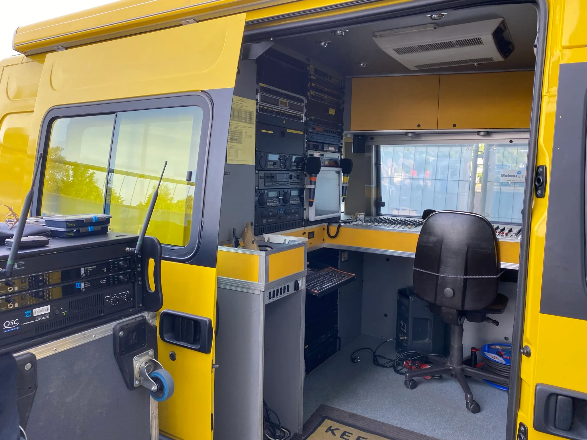 Blick in den kleinen Regiewagen mit Regieplatz und Technik