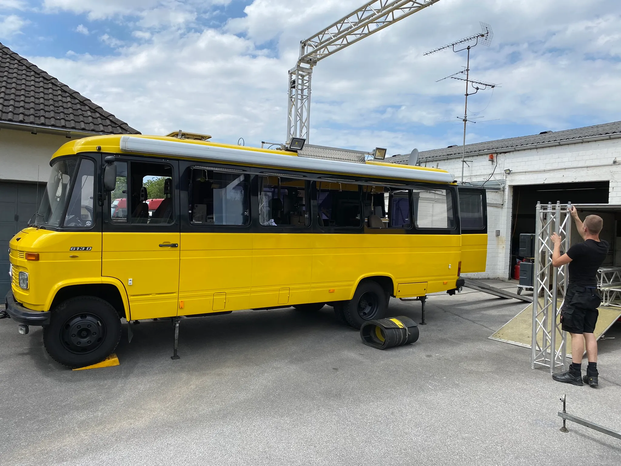 Der gelbe Zeitnahme-Regiewagen von Metronome mit geöffneter Seite vor der Halle
