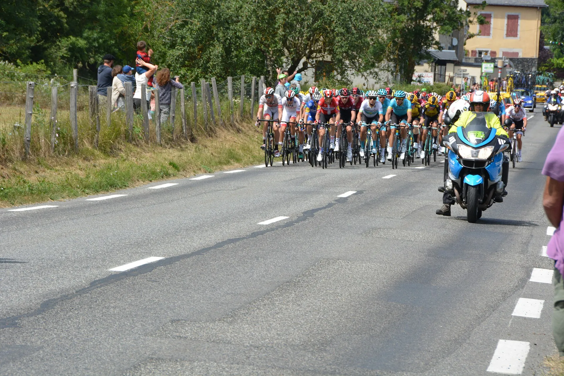 Peloton eines Straßenradrennens hinter dem Führungsmotorrad